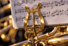 Primer plano de una partitura de música procesional colocada sobre el atril de un instrumento de viento metal