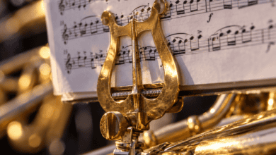 Primer plano de una partitura de música procesional colocada sobre el atril de un instrumento de viento metal