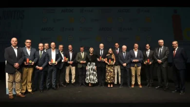 Detalle en plano macro del trofeo de los Premios a la Comunicación Experiencial de los Alimentos y Bebidas sobre mesa de madera.
