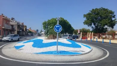 Primer plano de una baliza cilíndrica azul reflectante instalada en el borde de la acera para delimitar el tráfico.