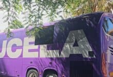 Autobús del Real Valladolid en un entorno con árboles y sombra.