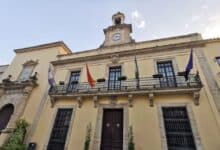 Edificio municipal en Jerez con banderas y reloj en la fachada.