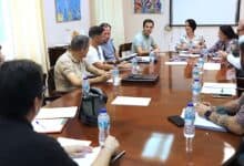 Primer plano de manos de estudiantes trabajando en grupo sobre papel borrador durante un taller escolar