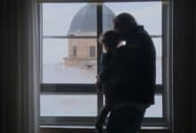Padre e hija mirando por la ventana en Cádiz, vista de la cúpula de la iglesia.