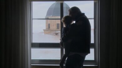 Padre e hija mirando por la ventana en Cádiz, vista de la cúpula de la iglesia.