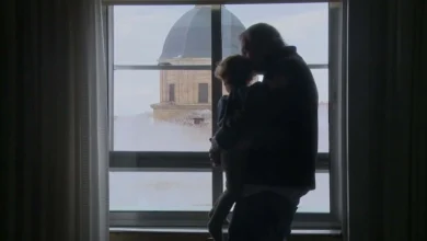 Padre e hija mirando por la ventana en Cádiz, vista de la cúpula de la iglesia.