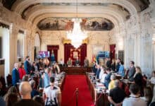 Reunión oficial en el ayuntamiento de Málaga con asistentes y autoridades.