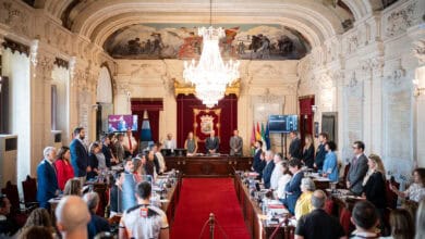 Reunión oficial en el ayuntamiento de Málaga con asistentes y autoridades.