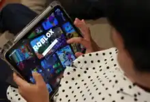 Niño jugando a Roblox en una tablet, enfoque en la pantalla.