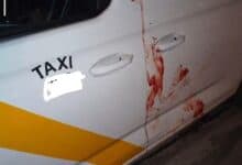 Coche de taxi con manchas de sangre en la puerta en Sevilla.