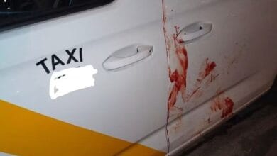 Coche de taxi con manchas de sangre en la puerta en Sevilla.