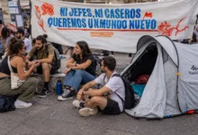 Personas sentadas junto a una tienda de campaña durante una movilización por el derecho a la vivienda
