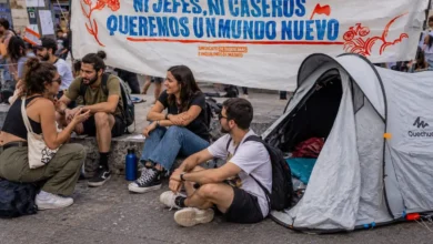 Personas sentadas junto a una tienda de campaña durante una movilización por el derecho a la vivienda