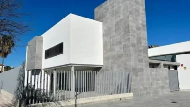 Vista exterior del nuevo edificio del Centro de Salud de La Dehesilla en Sanlúcar, con fachada de tonos blancos y grises y estructura moderna.