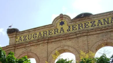 Fachada de ladrillo de la antigua Azucarera Jerezana con arcos y nidos de cigüeña bajo un cielo azul