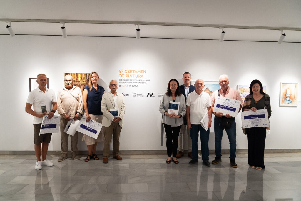Vista parcial de una exposición con varias pinturas enmarcadas junto al cartel del certamen en las Salas Mingorance.