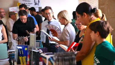 Personas consultando y comprando libros durante la Feria del Libro de Jerez en un espacio interior