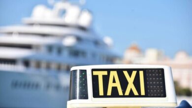 Rótulo de TAXI sobre un vehículo, con edificios desenfocados al fondo