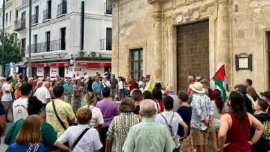 Personas concentradas ante un edificio histórico durante una movilización en Sanlúcar de Barrameda