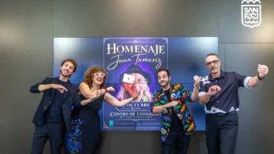 Cuatro personas posan ante una pantalla con el cartel del homenaje a Juan Tamariz en el Centro de Congresos de San Fernando.
