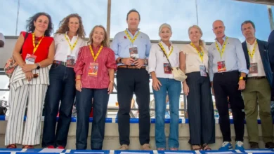 Grupo de varias personas con acreditaciones en las gradas de una instalación deportiva