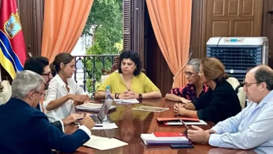 Reunión de varias personas alrededor de una mesa en una sala institucional
