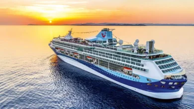 Crucero Marella Explorer navegando frente a la costa de Cádiz al atardecer, con el sol reflejándose sobre el mar.