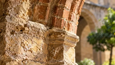Detalle de piedra antigua y arco de ladrillo en un espacio arquitectónico histórico de inspiración andalusí.