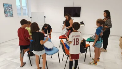 Alumnos y alumnas practican percusión en un aula junto a dos adultas durante una clase de la Escuela Municipal del Carnaval de Cádiz.