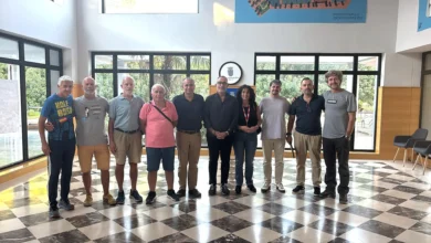Representantes de las entidades participantes en el II Circuito Local de Carreras Populares de Jerez posan juntos en una sala con grandes ventanales.