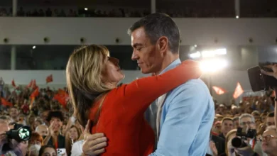 Pedro Sánchez y Begoña Gómez se abrazan ante un numeroso público durante un acto político.