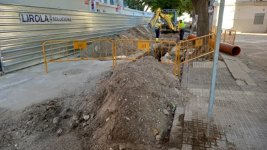Obras de canalización con maquinaria y trabajadores en una calle urbana