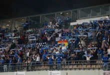 Aficionados en las gradas de un estadio levantan bufandas azules del Xerez CD.