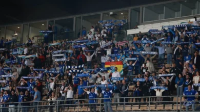 Aficionados en las gradas de un estadio levantan bufandas azules del Xerez CD.