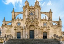 Fachada principal de la Catedral de Jerez con sus tres puertas, elementos ornamentales de piedra y escalinata de acceso.