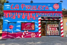 Fachada azul y rosa de La Piruleta en Jerez, decorada con piruletas y motivos de golosinas.