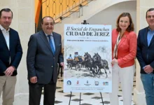 Cuatro personas posan junto al cartel de la II Social de Enganches Ciudad de Jerez en un espacio interior.