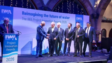 Varios participantes vestidos de traje durante una entrega de premios sobre el escenario de los IWA Project Innovation Awards 2026.