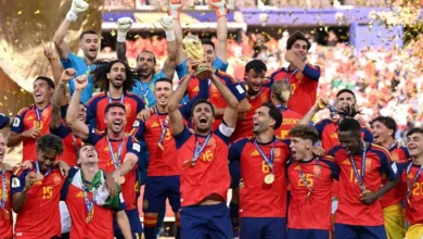La selección española de fútbol celebra un título con el trofeo levantado y confeti en el estadio.