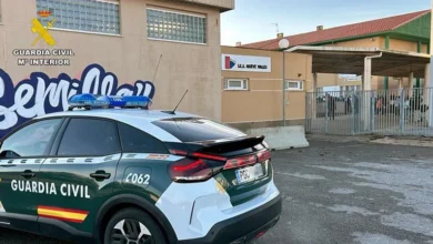 Vehículo de la Guardia Civil estacionado frente a un centro educativo, junto a la entrada del recinto escolar.