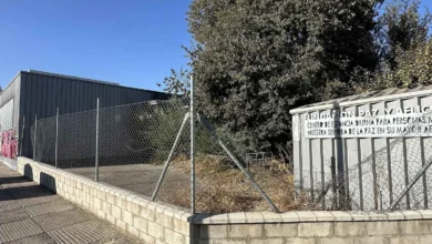 Antiguo Centro de Mayores de la Fundación Paz y Aflicción en Jerez, con parcela vallada, vegetación seca y edificio al fondo.