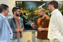 Cuatro hombres conversan delante de una pantalla que muestra el cartel de Así canta Jerez en Navidad en Sanlúcar de Barrameda.