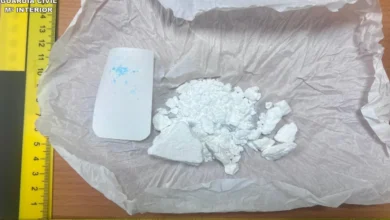 Fragmentos blancos sobre una bolsa de plástico junto a una regla amarilla de medición y una pieza rectangular blanca.
