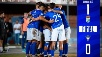 Jugadores del Xerez CD, vestidos de azul, celebran juntos la victoria ante el Marbella FC junto al marcador final de 1-0.
