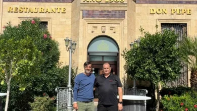 Dos hombres posan delante de la entrada del Restaurante Don Pepe, con una fachada de piedra, vegetación y el rótulo del establecimiento.