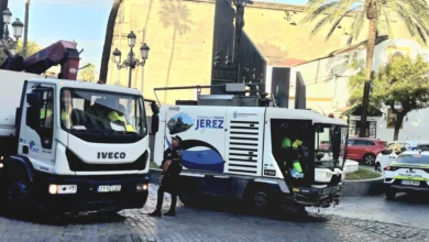 Camión de limpieza viaria y vehículo de la Policía Local en una calle de Jerez.