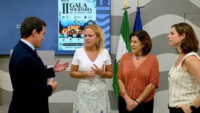 Cuatro personas participan en la presentación de la II Gala Solidaria de Autismo Cádiz, con el cartel del evento al fondo y las banderas de Andalucía y España.