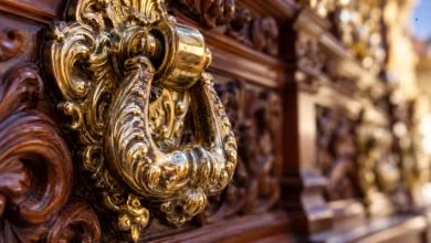 Primer plano de un llamador metálico sobre madera tallada de un paso procesional, con detalles ornamentales y reflejos dorados.