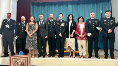 Grupo de personas posa sobre un escenario durante un acto institucional con varias personas uniformadas y otras vestidas de civil.