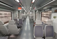 Primer plano de las ruedas y los componentes metálicos de un tren de Cercanías sobre las vías ferroviarias.